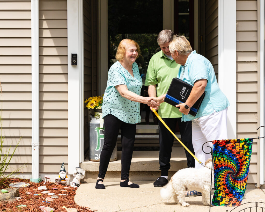 An ADRC specialist shaking the hand of her client at a home visit