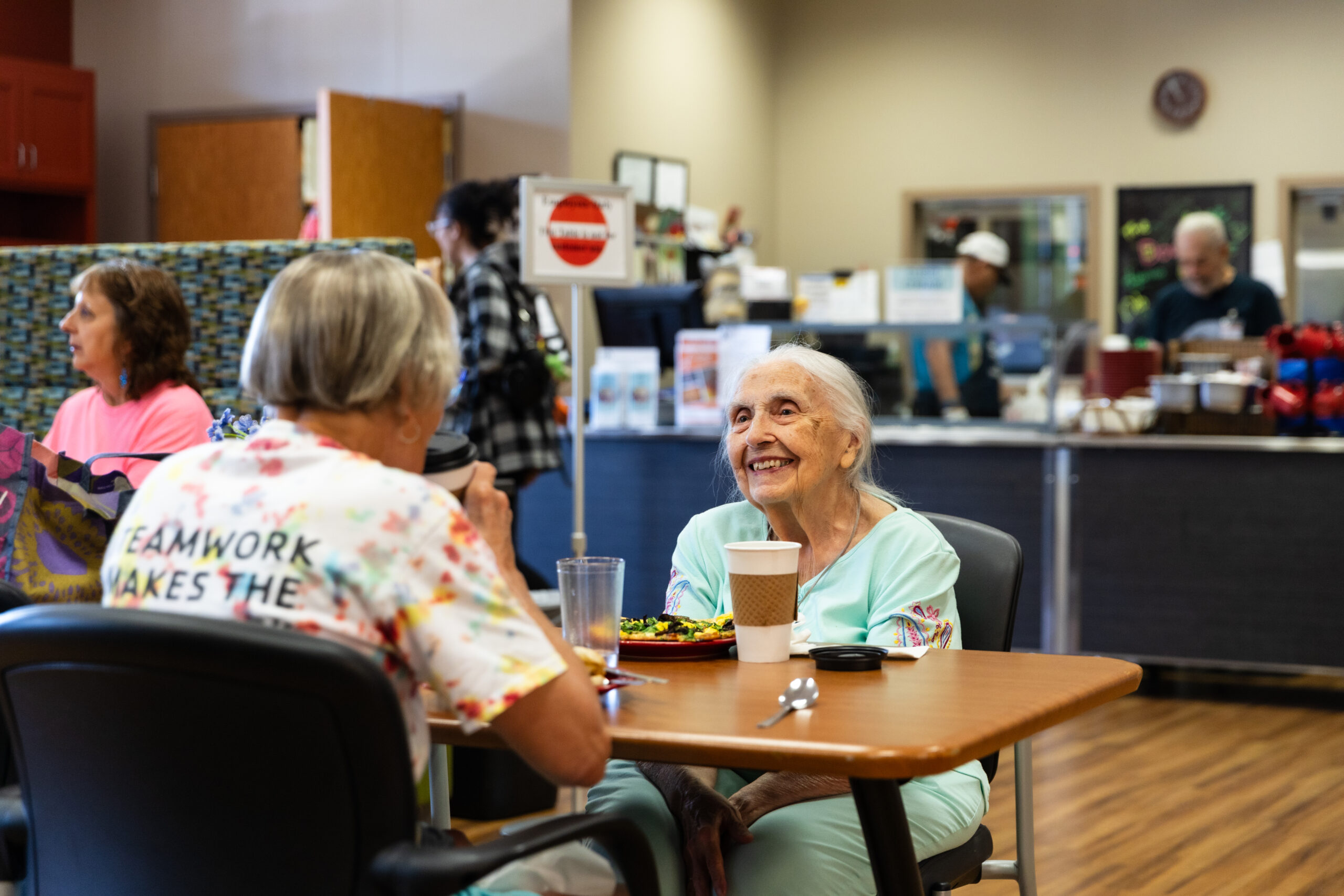 two women smiling having lunch and a conversation together at the ADRC