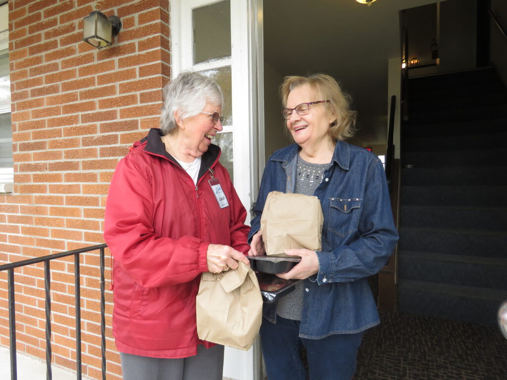 Volunteer delivering meals to a homebound meal recipient